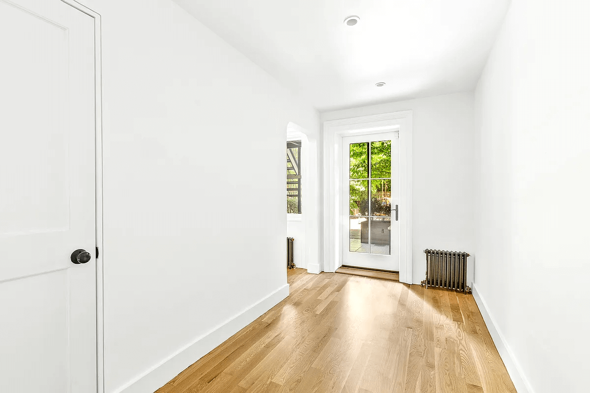 a narrow bedroom with a door to the rear garden