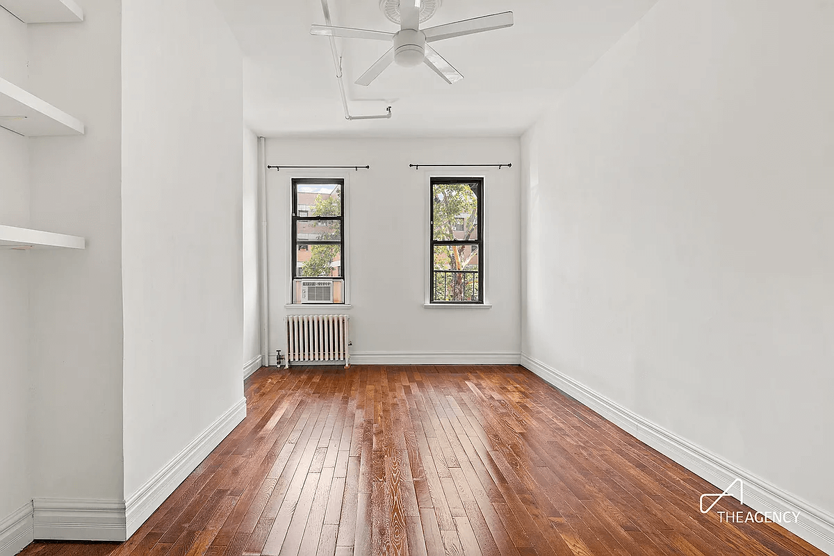 living room with ceiling fan and built-in shelves