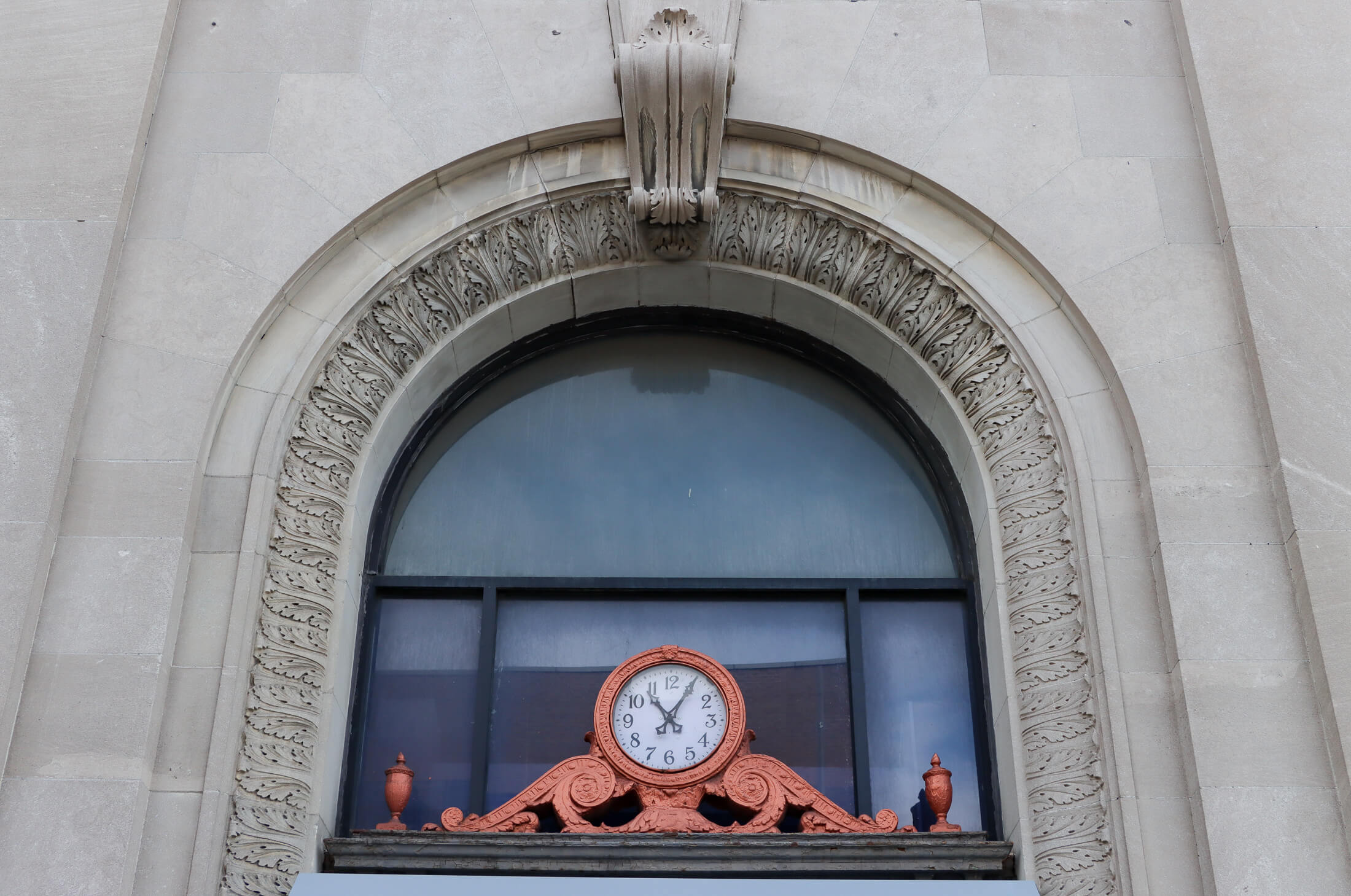 a copper painted clock above the entrance to the bank