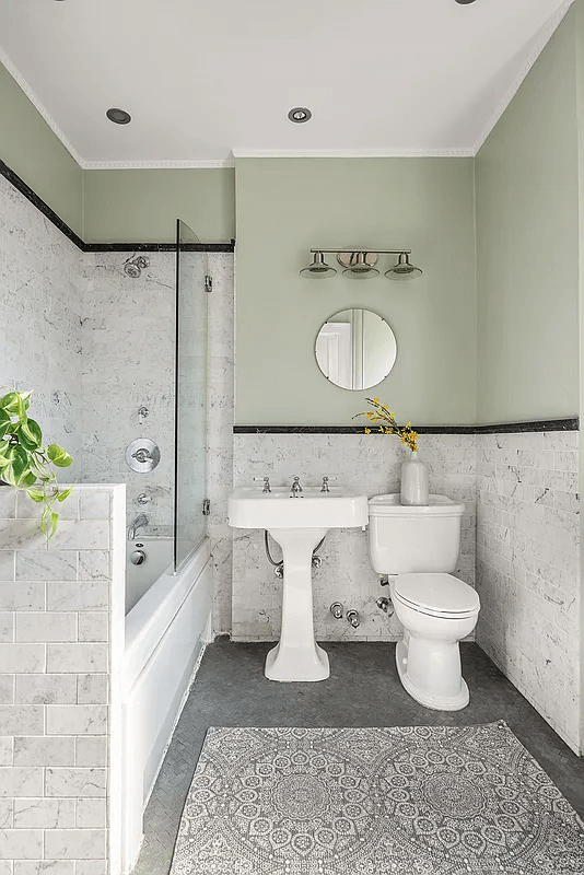 bathroom with marble wall tiles and white fixtures