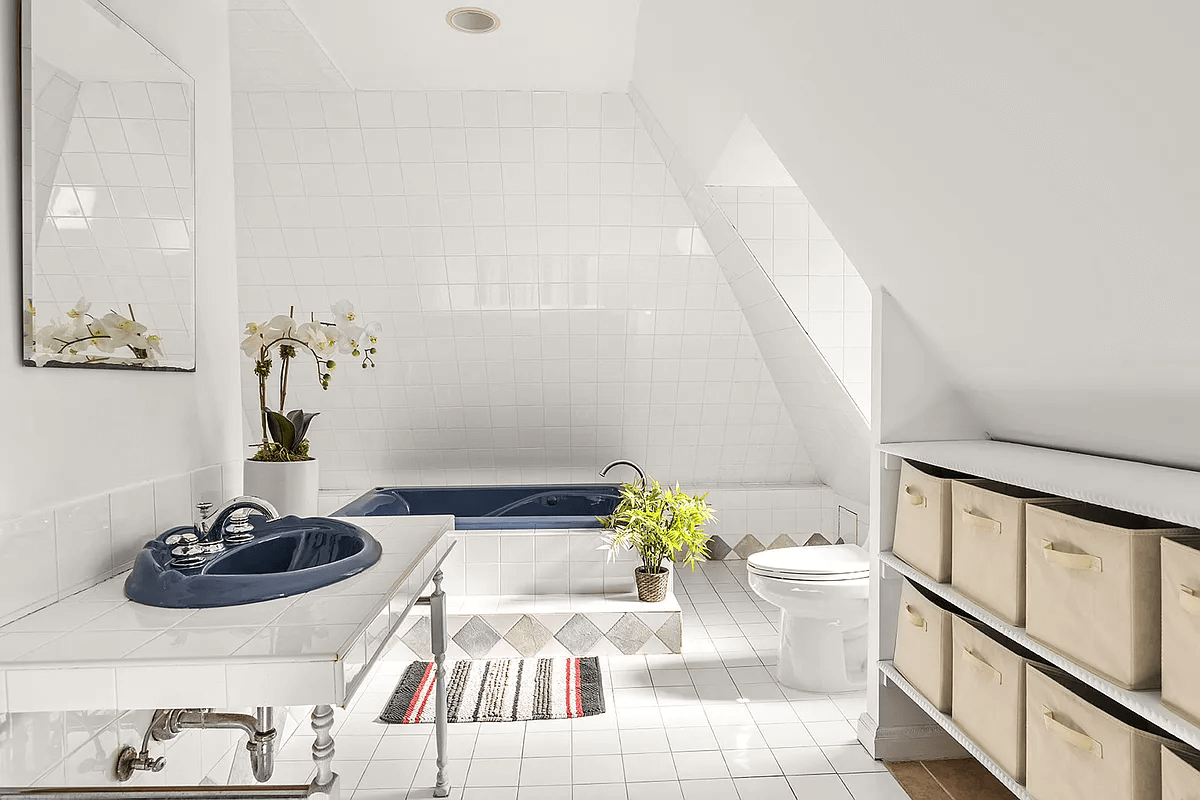 bathroom with white tiled surround enclosing the blue bath tub