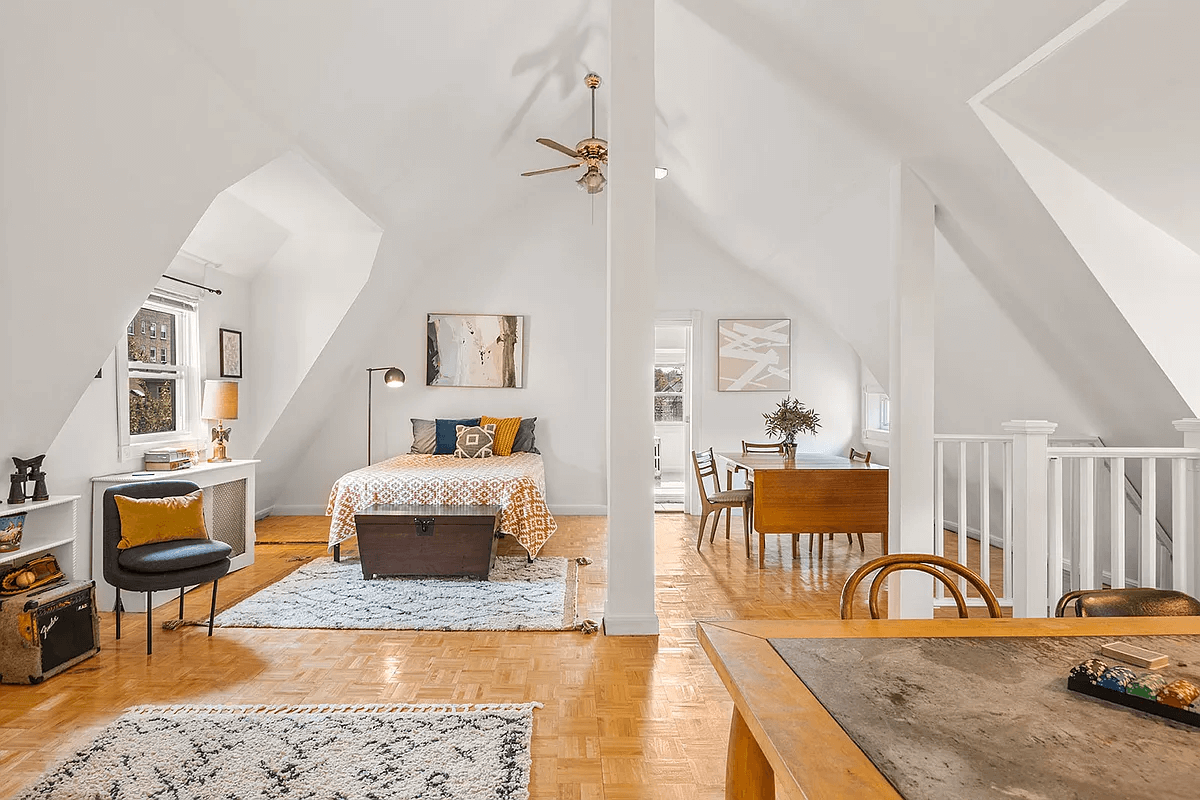 attic bedroom with ceiling fan and parquet floor