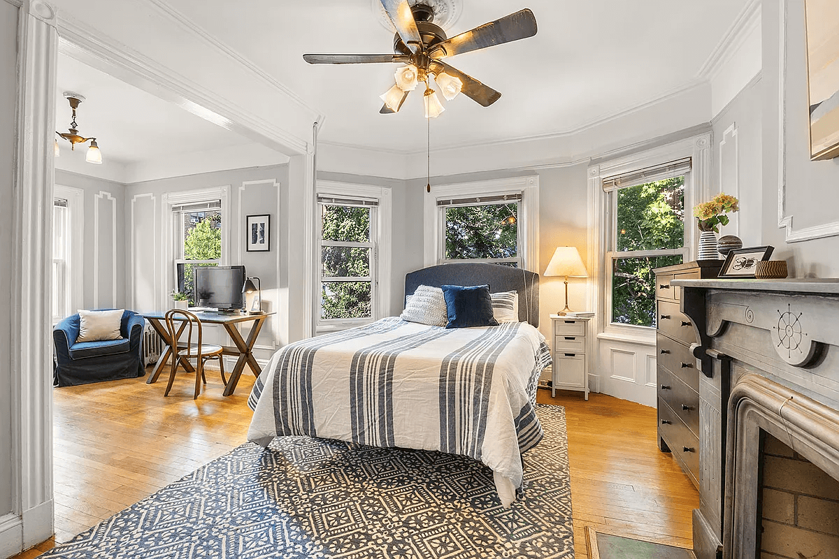 bedroom with etched mantel, two exposures and a sitting area