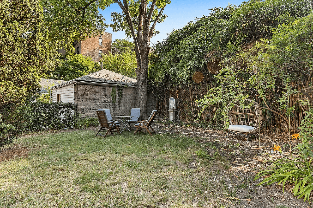 rear yard with view of cement block garage