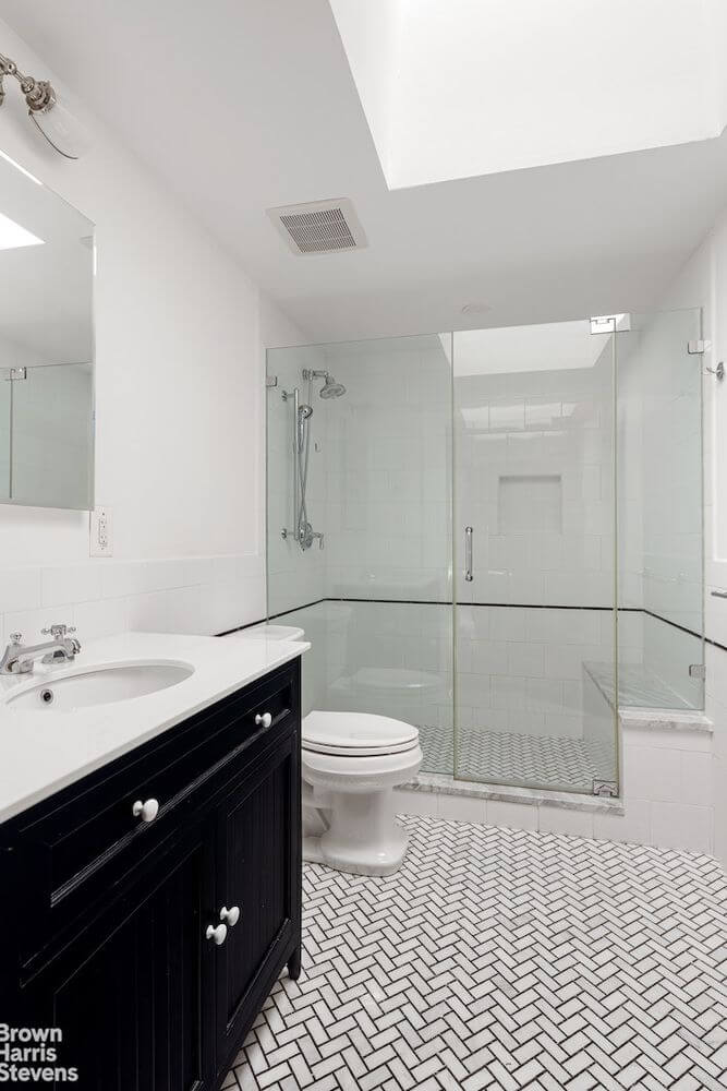bathroom with glass shower and black vanity