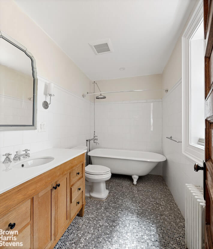 bathroom with claw foot tub and wood vanity