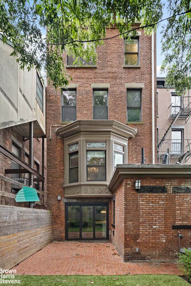 view of brick rear of the house with bay window