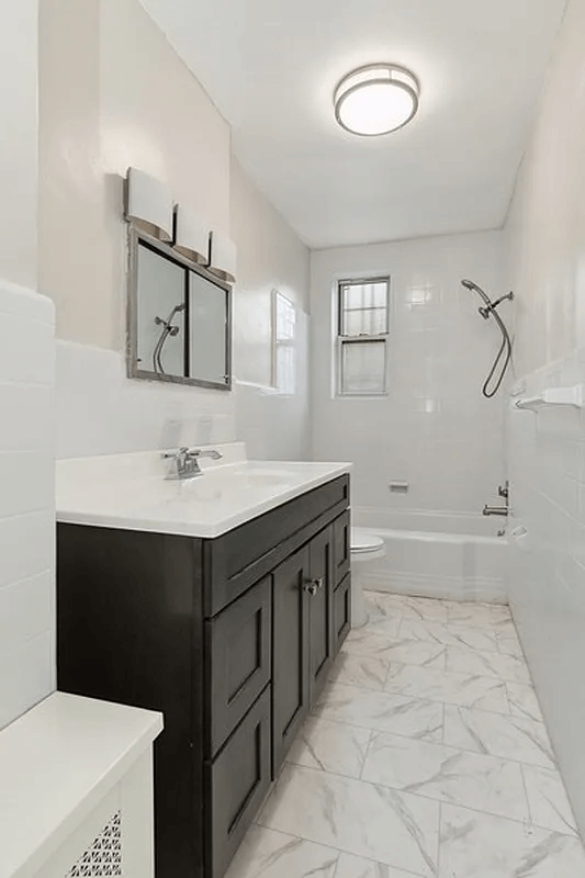 bathroom with wood vanity and white fixtures