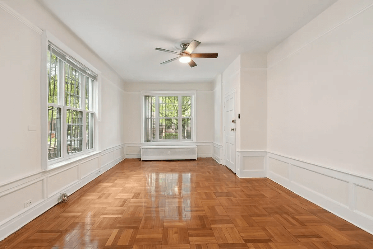 living room with two exposures and a ceiling fan