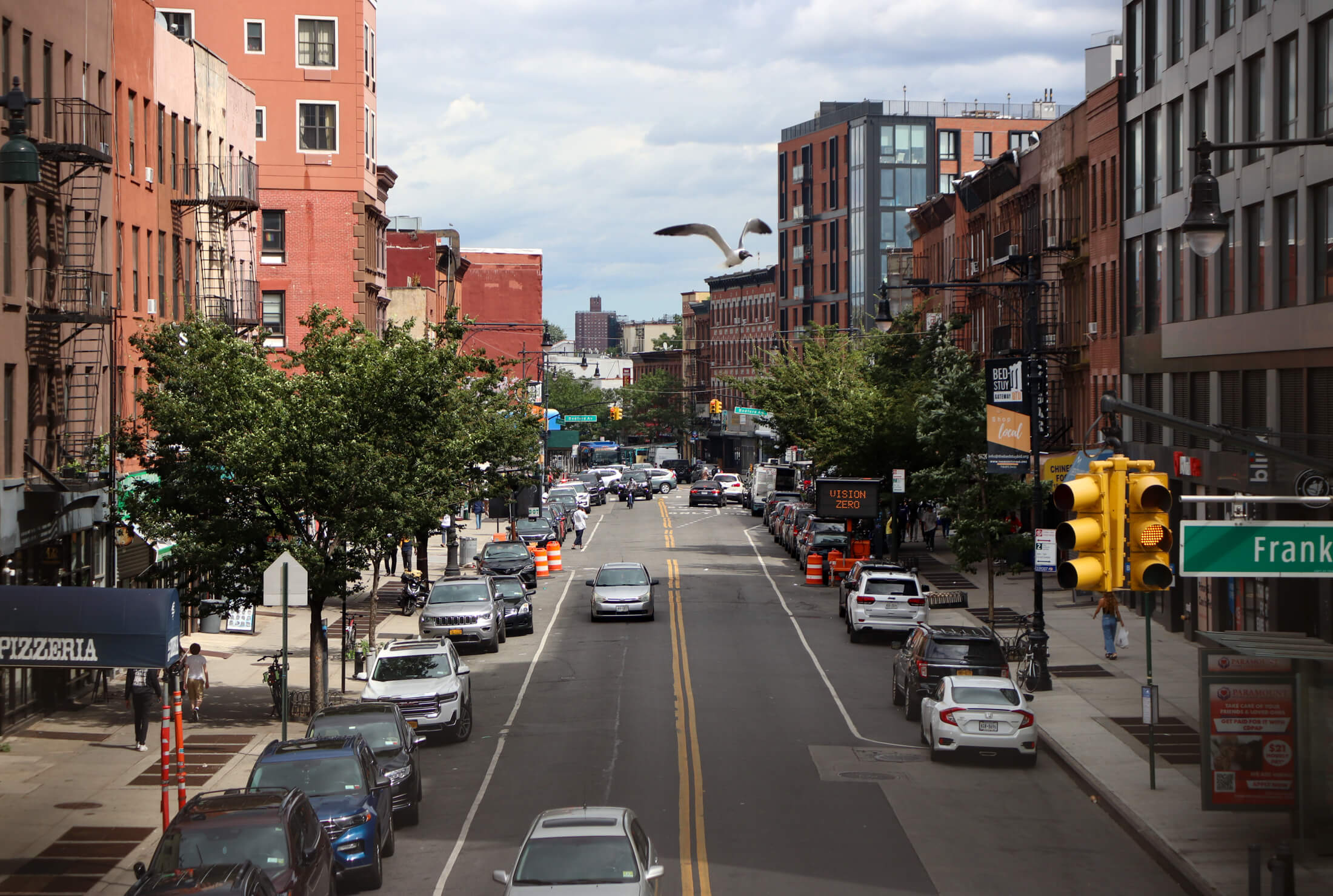 a view looking on fulton street with a bird flying above