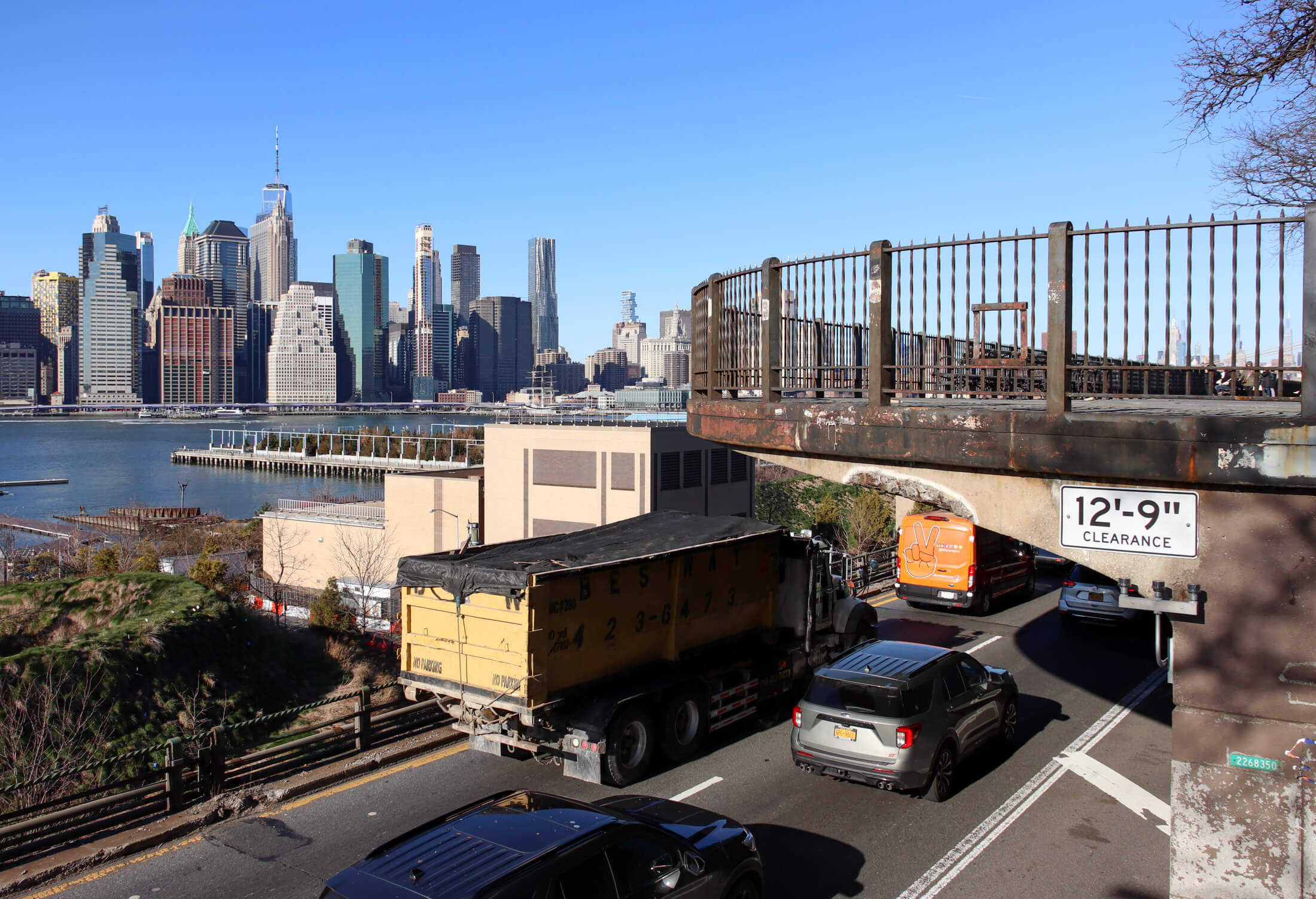 a truck on the bqe with the manhattan skyline in the background