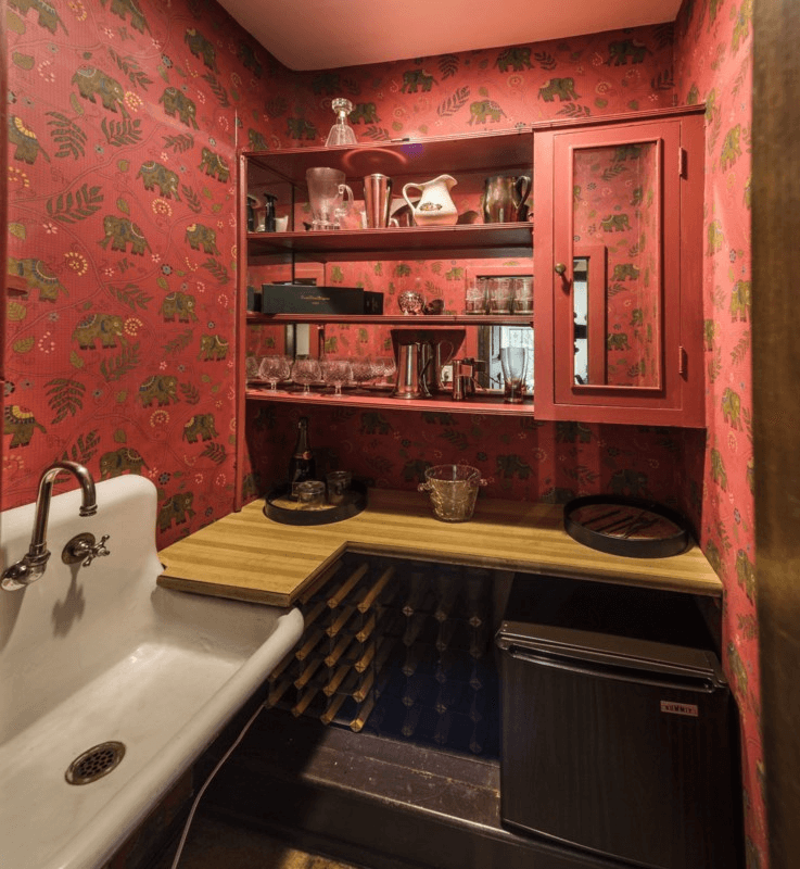 bar with vintage sink and red wallpaper with elephants