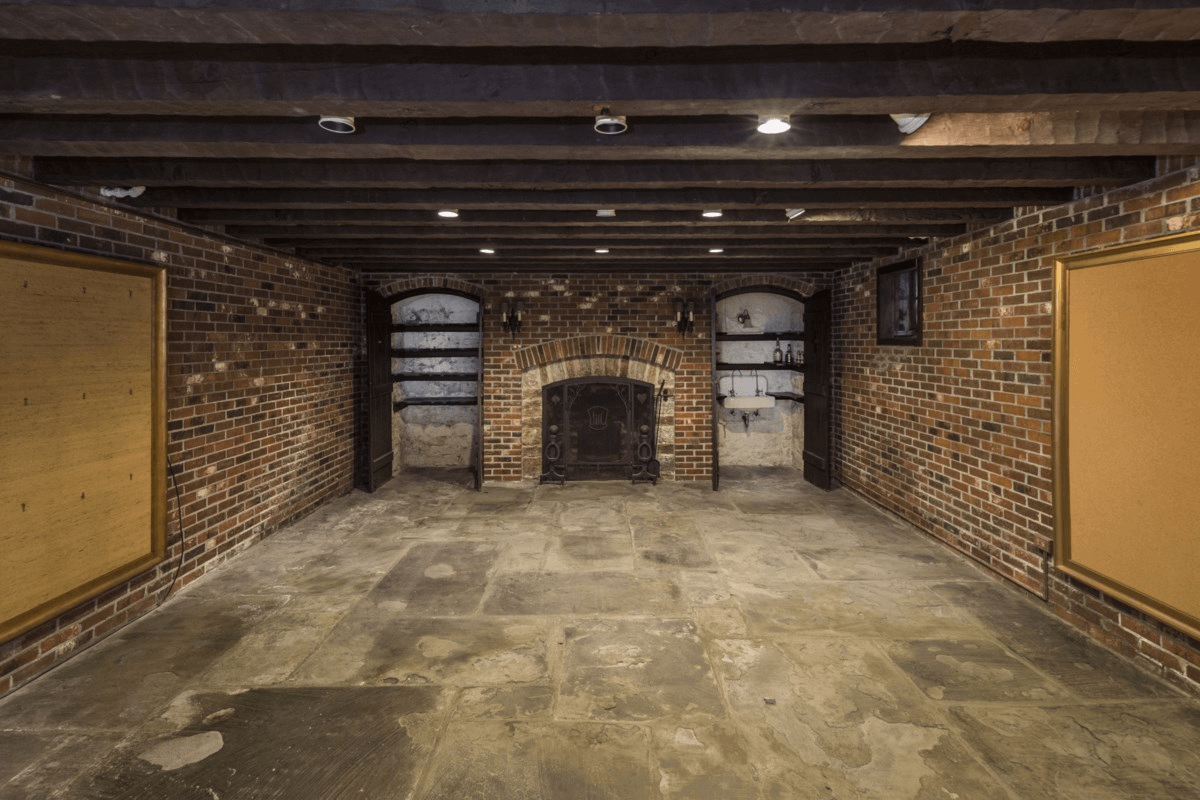 basement with brick walls and a hearth