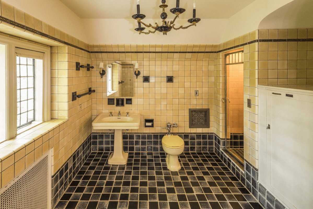 vintage bathroom with yellow fixtures and wall tile and black accents and floor tile