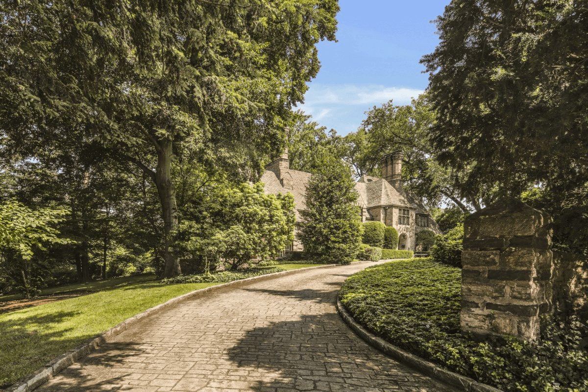 view of paved drive leading to house