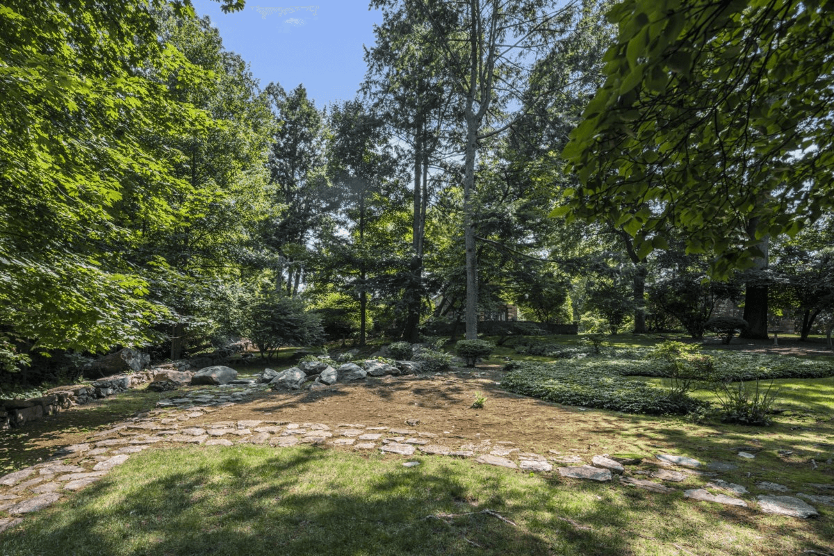 view of lawn with large trees