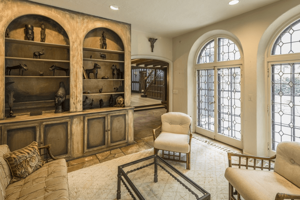 sunroom with built-in shelves and arched windows