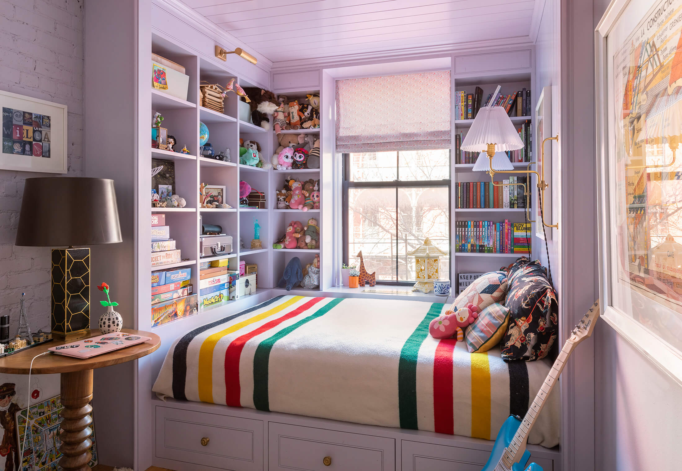 a bed built into an alcove with bookshelves