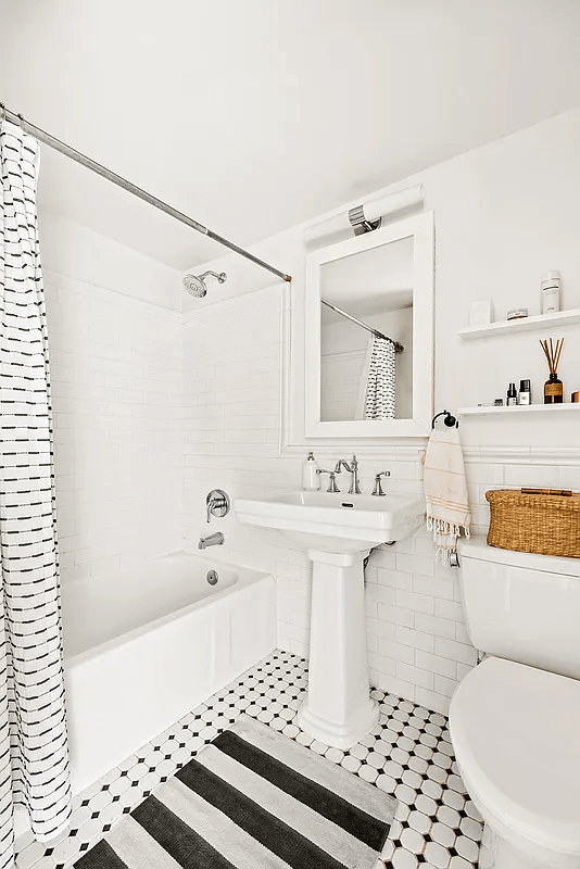 bathroom with white fixtures and black and white tile floor