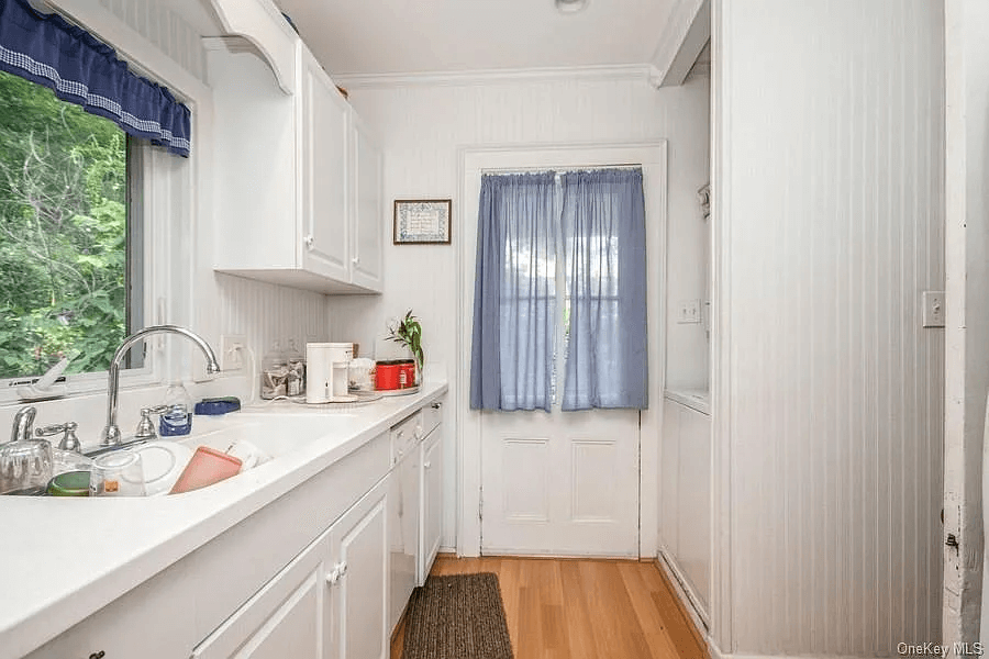 galley kitchen with beadboard walls and white abinets