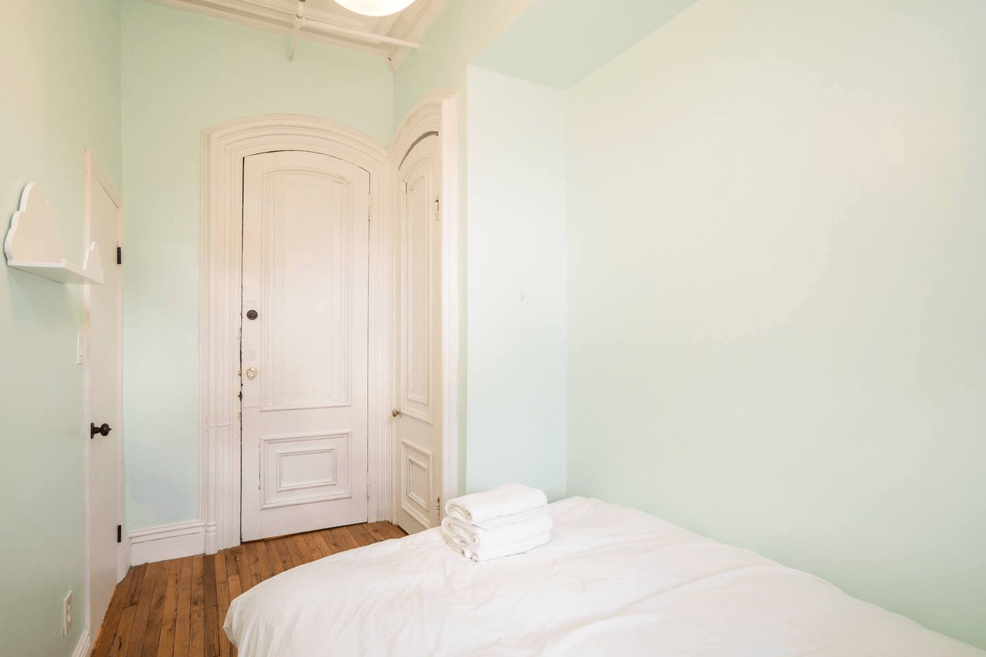 narrow bedroom with door moldings and a closet