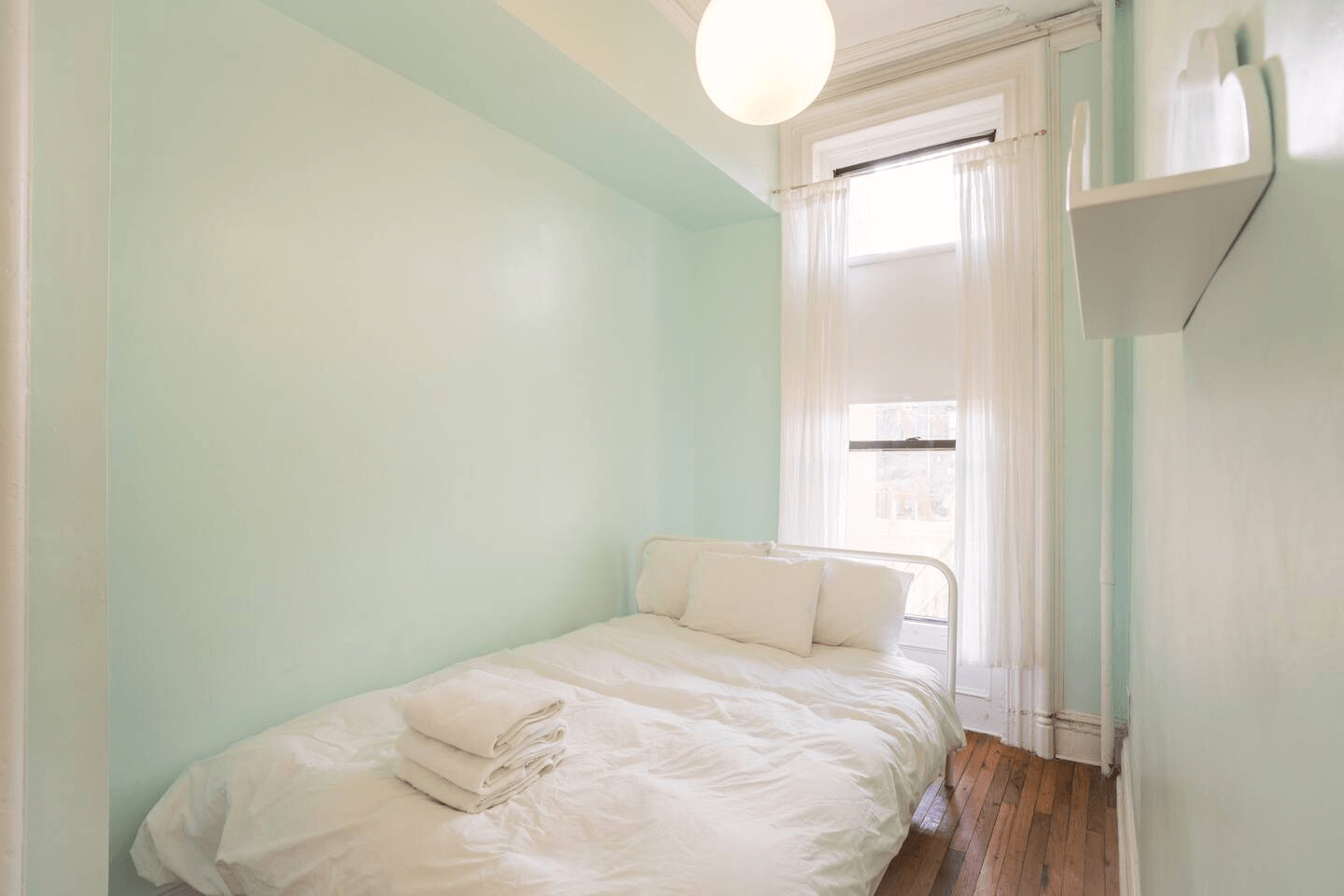 narrow bedroom with pastel walls