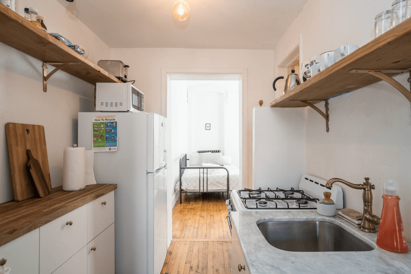 kitchen with open shelving and view into bedroom