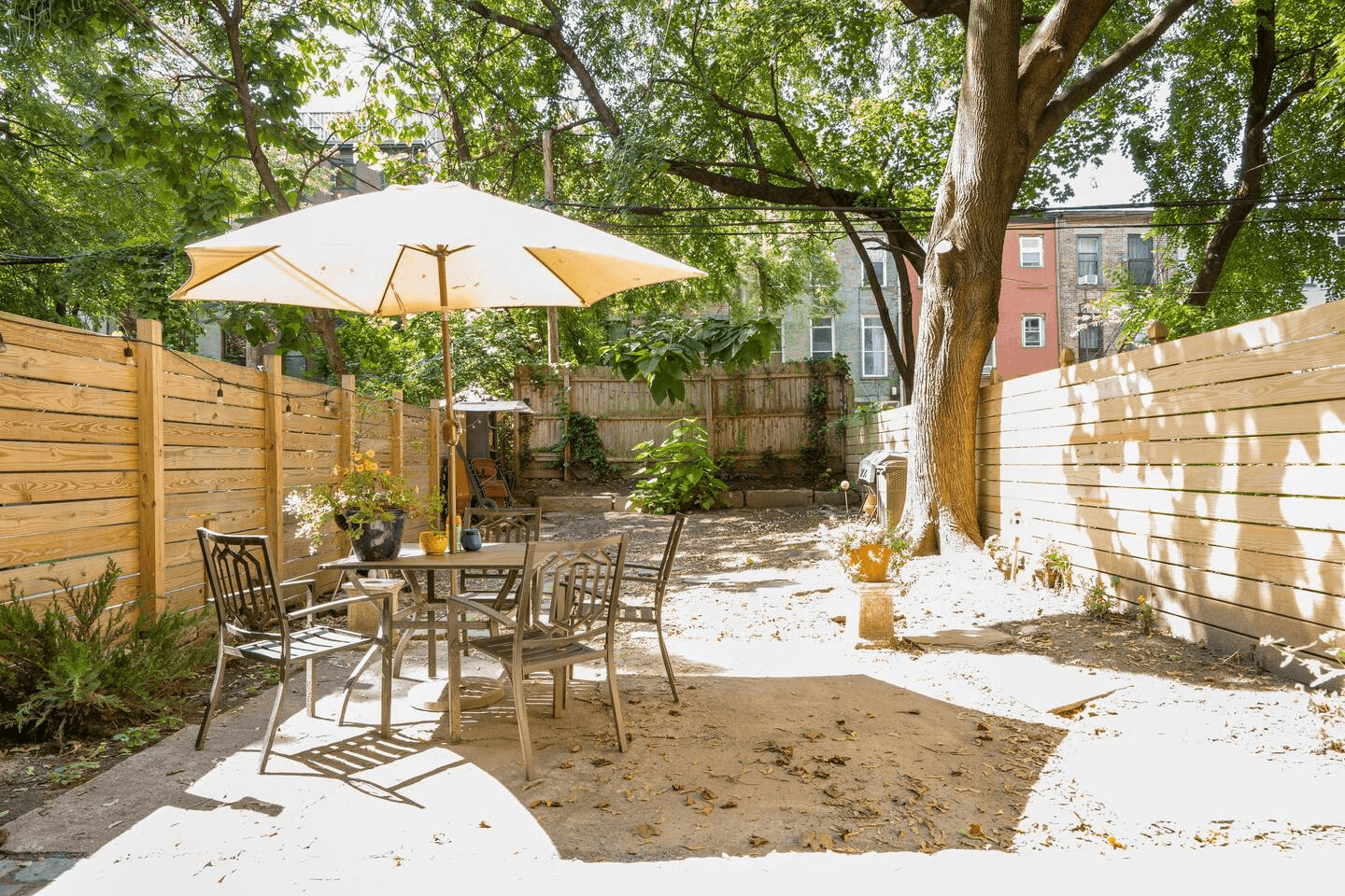 fenced-in rear yard with a tree