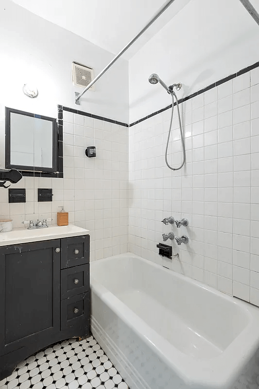 bathroom with vintage white tub and a black vanity