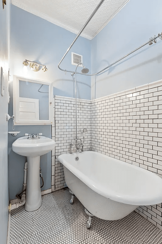 bath room with hex tile floor and white claw foot tub