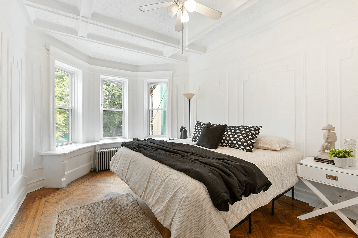 bedroom with wall moldings and a bay window