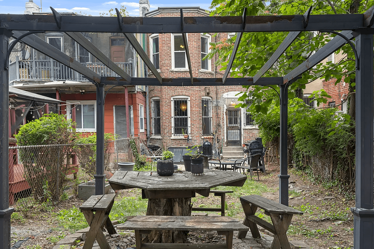 view of brick rear of the house and the pergola in the rear yard
