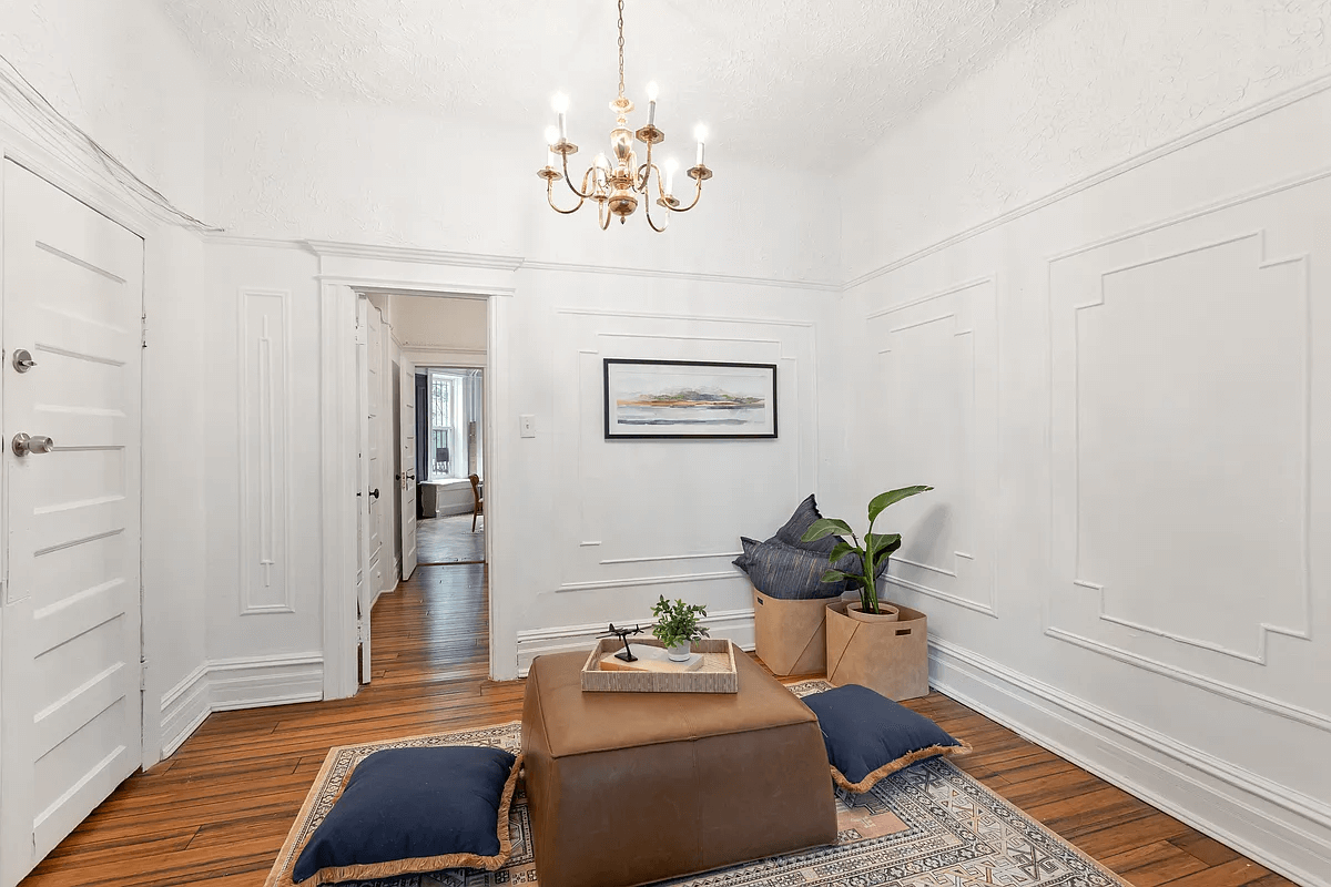 living room with chandelier and wall moldings