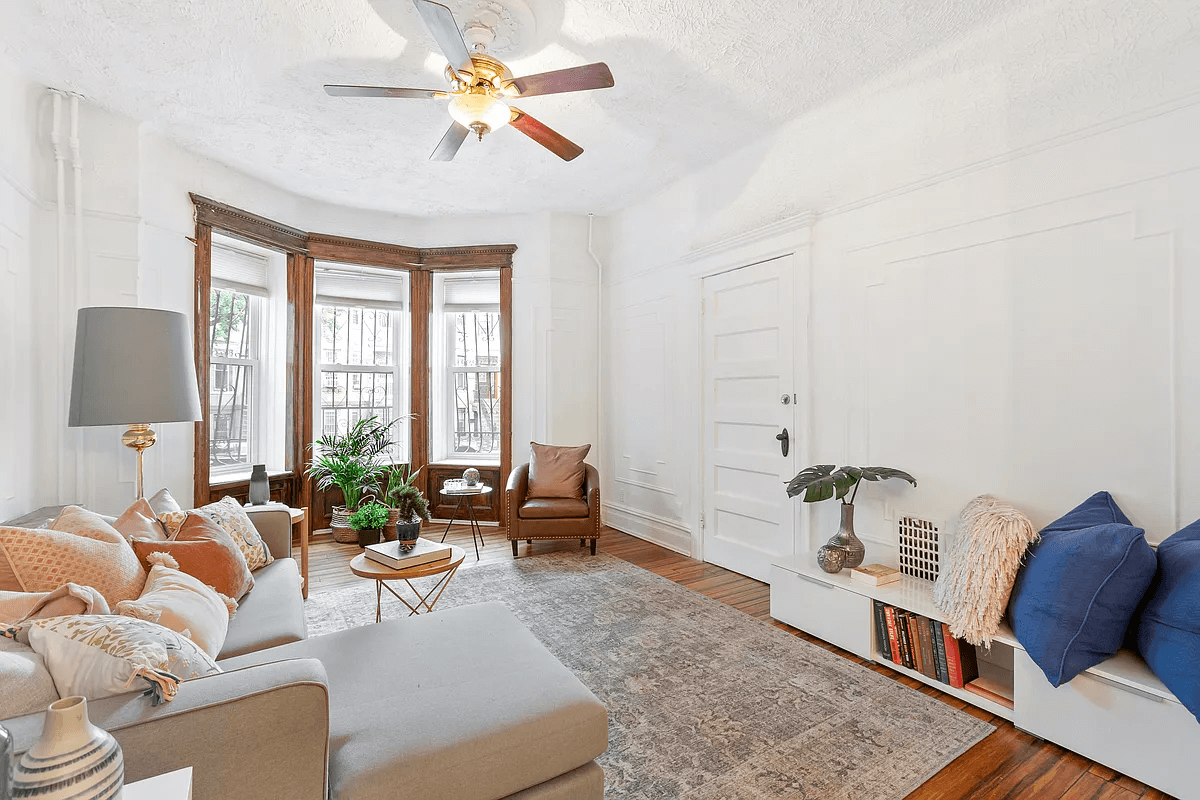 living room with wall moldings, picture rails and a ceiling fan