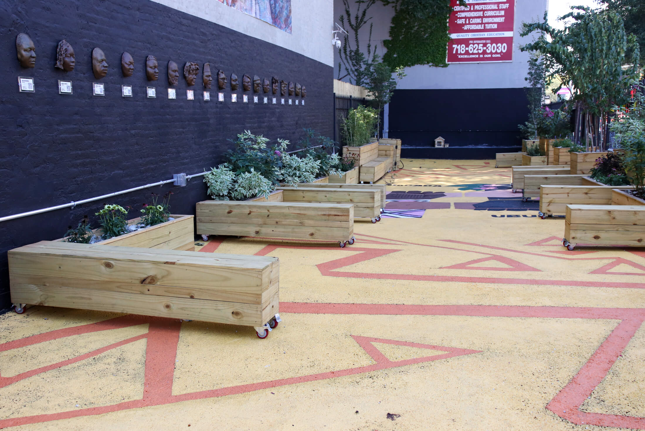 view of space with painted mural on ground and wood benches and planters