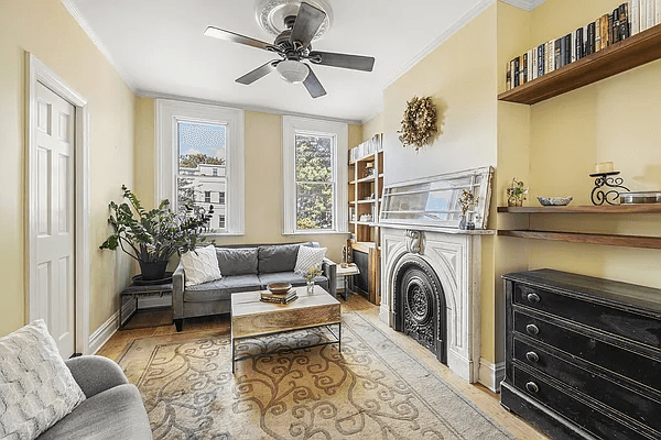 brooklyn open house - narrow parlor with a marble mantel and a ceiling fan