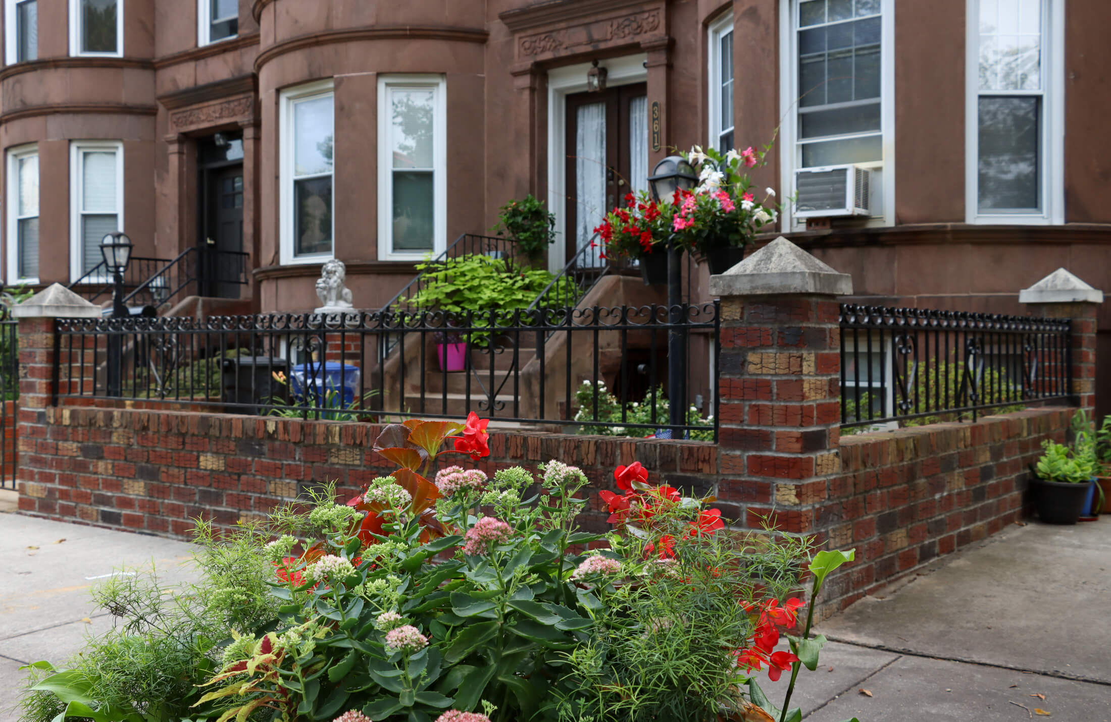 flowers in a planter in front of a brownstone