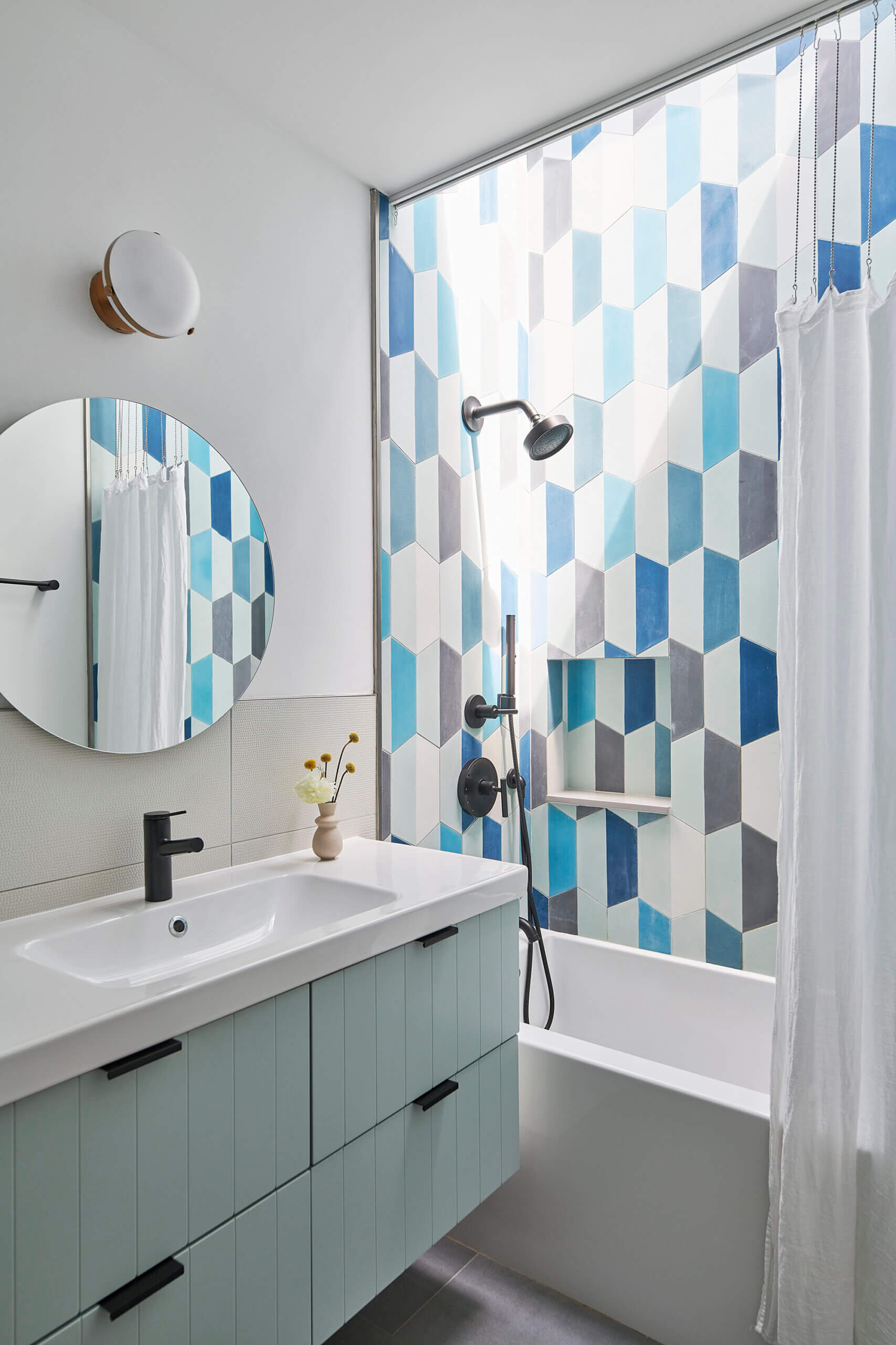 BATHROOM with graphic blue tile walls surrounding the tub