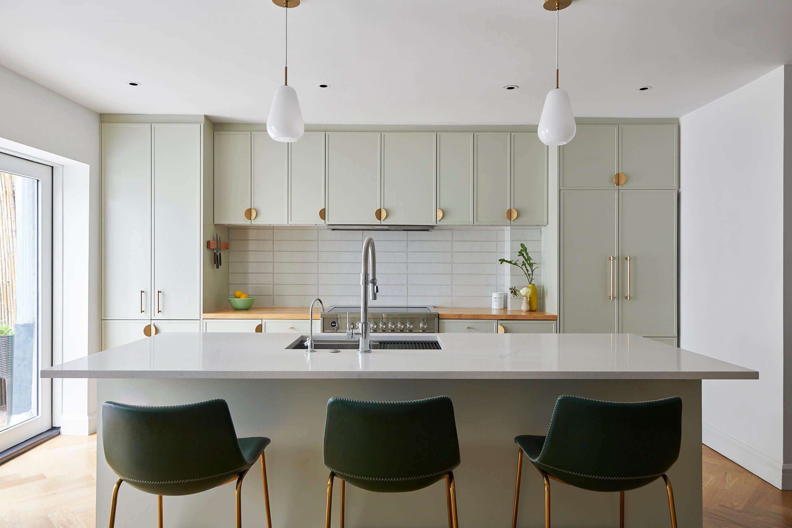 KITCHEN with a large island and pale green cabinets