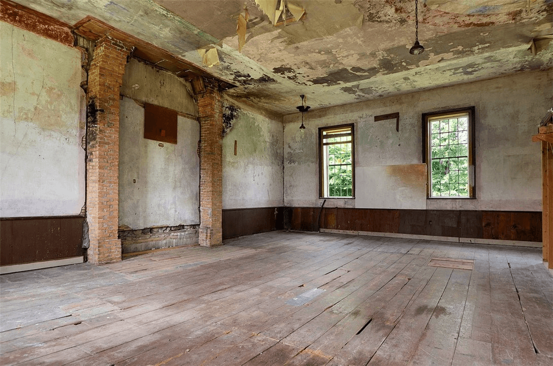 the original worship space with wide plank wood floors and plaster walls