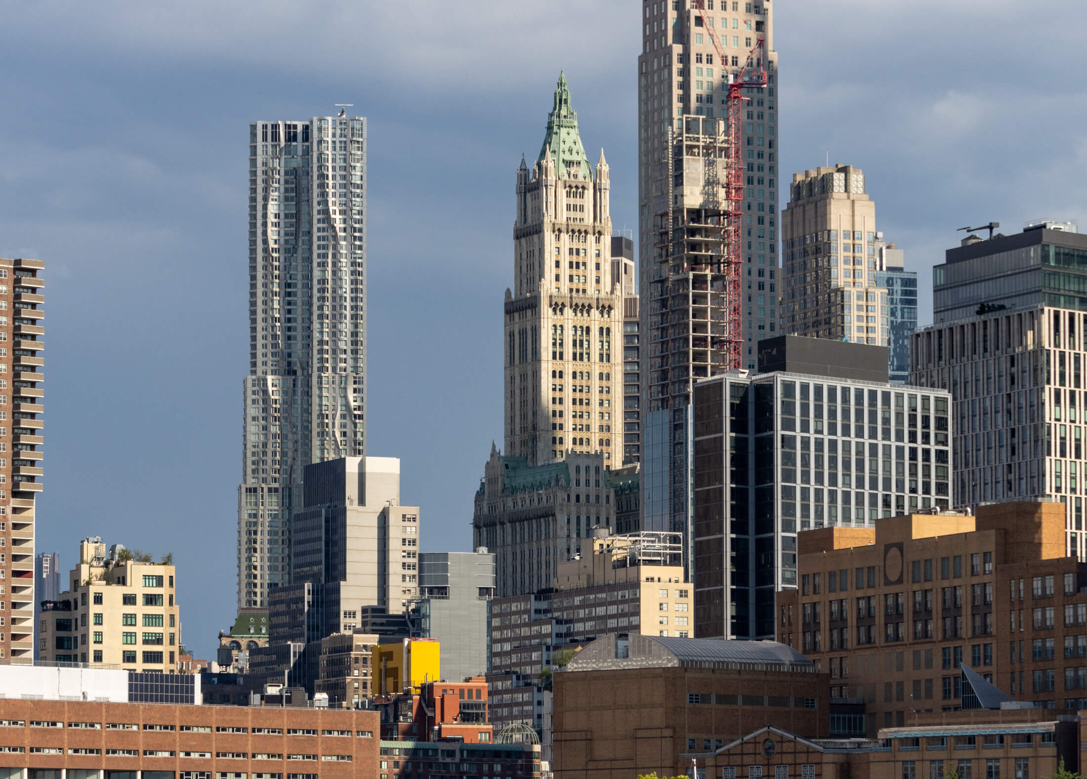 the manhattan skyline from the hudson river showing the wooolworth building surrounded by modern towers