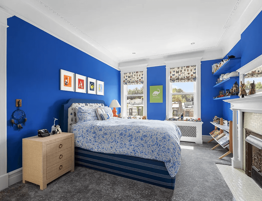 bedroom with mantel and bright blue walls