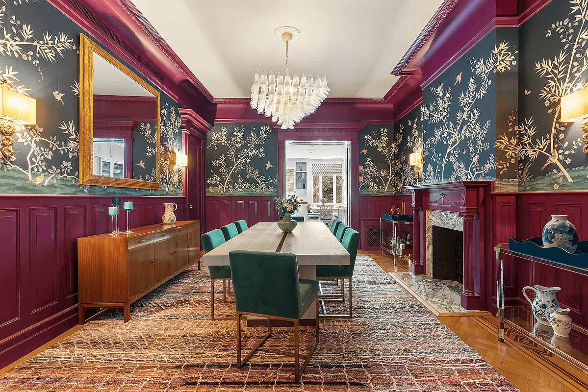 dinig room with magenta painted wainscoting and dark wallpaper