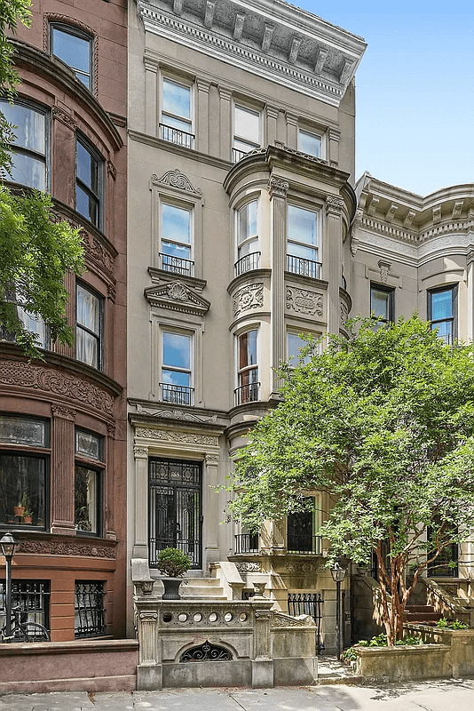 exterior of the house with a stoop and a multiple story bay window