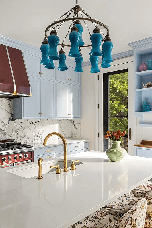 kitchen island with a sink and a blue chandelier above