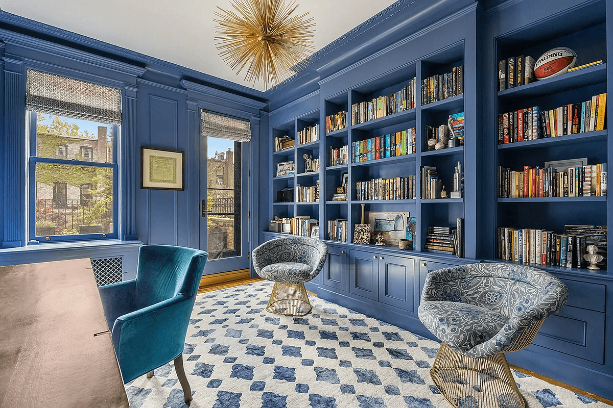 library with blue walls, built-in shelves and door to terrace