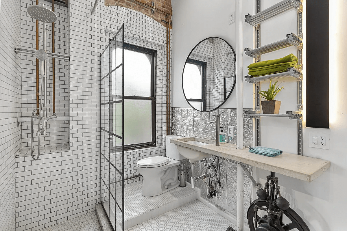 bathroom with glass wall to shower, exposed brick and white subway tile