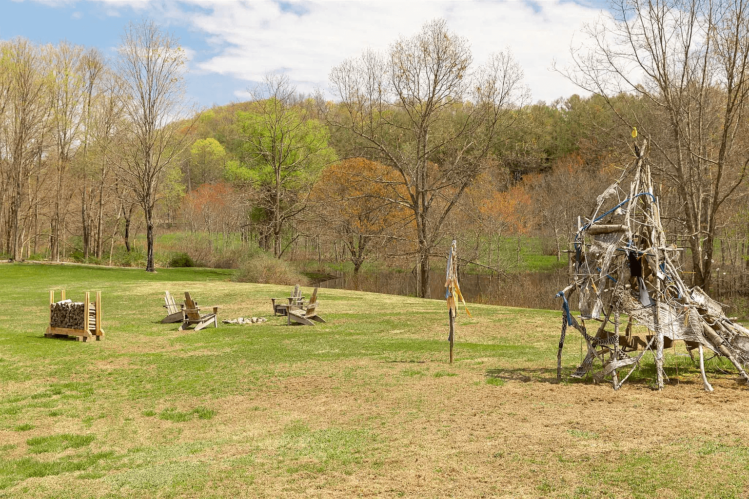 view of lawn with fire pit and view of woods