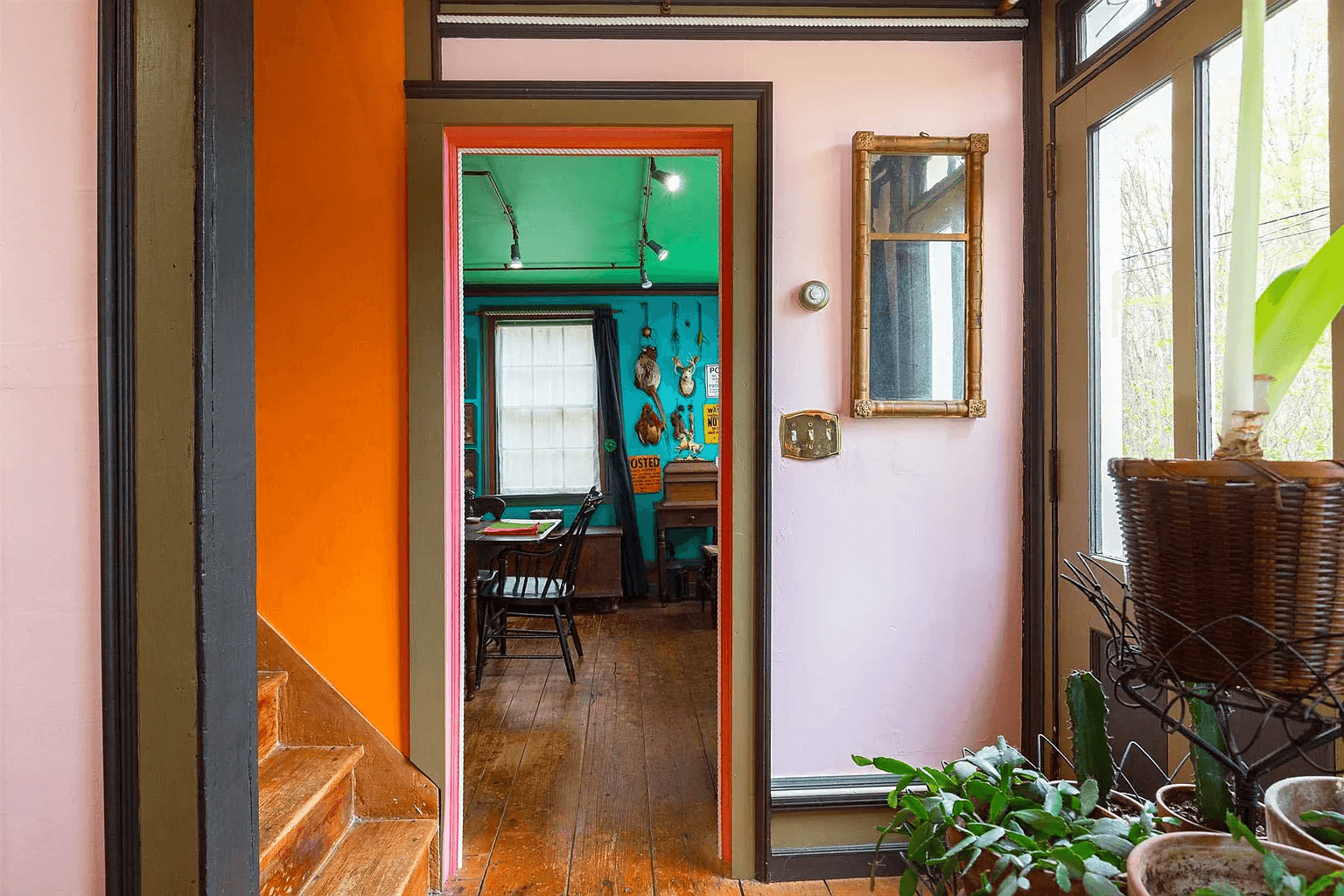 glimpse of stairs with orange walls and into the library