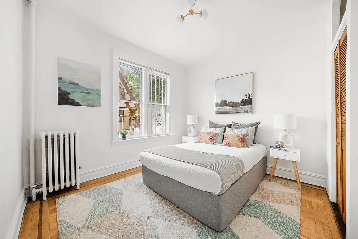 bedroom with wood floors and a louvered closet door